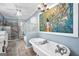Bright bathroom features a standalone tub, tiled shower, double sink vanity, and stylish accents at 701 Mask Rd, Brooks, GA 30205