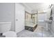 Bathroom with a tub-shower combination featuring glass block surround and a pedestal sink at 701 Mask Rd, Brooks, GA 30205