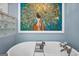 Elegant standalone bathtub accented by modern fixtures and colorful artwork in a cozy, tiled bathroom at 701 Mask Rd, Brooks, GA 30205