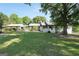Charming white brick home with a lush green lawn and mature trees on a sunny day at 701 Mask Rd, Brooks, GA 30205