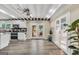 A stylish kitchen with white cabinets, an island, stone accents and stainless steel appliances, adjacent to the living area at 701 Mask Rd, Brooks, GA 30205