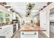 Spacious open kitchen with white cabinets, stone detailing, a large island, and stainless steel appliances at 701 Mask Rd, Brooks, GA 30205