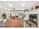 Comfortable living room featuring a fireplace, beams, and wood-look floors at 701 Mask Rd, Brooks, GA 30205