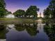 Picturesque pond reflecting the charming house, trees, and gazebo at dusk, creating a serene atmosphere at 701 Mask Rd, Brooks, GA 30205