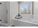 Bright bathroom with a soaking tub, white subway tile, and modern black fixtures at 4186 Highway 138 Sw, Stockbridge, GA 30281