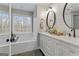 Well-lit bathroom with double vanity, soaking tub, and modern fixtures at 4186 Highway 138 Sw, Stockbridge, GA 30281