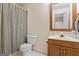 Well-lit bathroom featuring a shower with black and white checkered curtains, a vanity, and a toilet at 4186 Highway 138 Sw, Stockbridge, GA 30281