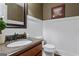 Powder room featuring granite counters, white wainscoting, and earth-tone paint at 4186 Highway 138 Sw, Stockbridge, GA 30281