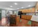 Open kitchen with wood cabinets, brick floors, barstool seating, and black appliances at 4186 Highway 138 Sw, Stockbridge, GA 30281
