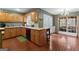 Spacious kitchen with wood cabinets, brick floors, barstool seating, and view to sunroom at 4186 Highway 138 Sw, Stockbridge, GA 30281