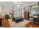 Elegant main bedroom with a four-poster bed, hardwood floors, and a decorative tray ceiling at 4186 Highway 138 Sw, Stockbridge, GA 30281