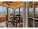 Enclosed sunroom with wooden ceiling, string lights, wooded views, and cozy seating area at 4186 Highway 138 Sw, Stockbridge, GA 30281