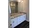 Primary bath with double sinks, granite counters, and large mirror over white vanity at 606 Gardner Rd, Stockbridge, GA 30281