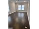 Large bedroom with hardwood floors, neutral paint, and plenty of natural light from two windows at 606 Gardner Rd, Stockbridge, GA 30281