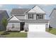Charming two-story home with gray siding, white trim, and an attached two-car garage at 438 Prescott Way, Villa Rica, GA 30180