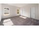A light-filled bedroom with neutral carpet, two windows and a white door at 442 Prescott Way, Villa Rica, GA 30180