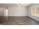 Spacious living area with a ceiling fan, expansive windows, and modern flooring, providing a comfortable open layout at 442 Prescott Way, Villa Rica, GA 30180