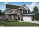 Charming two-story home featuring a two-car garage, gray brick, and a well-manicured front lawn at 425 Prescott Way, Villa Rica, GA 30180