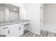 Bathroom featuring a granite vanity top, mirror, and white cabinets with wood-look flooring at 445 Prescott Way, Villa Rica, GA 30180