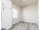Bright dining area featuring wood-look flooring, a large window, and modern white cabinets at 445 Prescott Way, Villa Rica, GA 30180