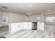 Modern kitchen with white cabinets, granite counters, stainless appliances, and light gray wood floors at 445 Prescott Way, Villa Rica, GA 30180
