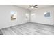 Bright bedroom features large windows, light gray wood floors, and a ceiling fan at 448 Prescott Way, Villa Rica, GA 30180
