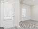 Bright entryway featuring a white door with blinds, light gray wood floors, and neutral walls at 448 Prescott Way, Villa Rica, GA 30180