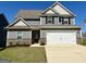 Beautiful two-story home featuring a two-car garage, gray siding and a well-manicured lawn at 448 Prescott Way, Villa Rica, GA 30180