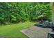 Large backyard with green grass, back deck, and concrete area at 242 Greenland Dr, Mcdonough, GA 30253