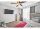 Inviting bedroom with a mounted TV, dresser, area rug, and a ceiling fan at 242 Greenland Dr, Mcdonough, GA 30253