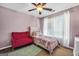 Cozy bedroom with a decorative ceiling fan, vibrant sofa, and colorful bed at 242 Greenland Dr, Mcdonough, GA 30253