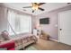 Bright bedroom featuring a ceiling fan, mounted TV, and unique decor at 242 Greenland Dr, Mcdonough, GA 30253