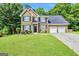 Charming brick home with a well-manicured lawn, dark shutters, and an attached two-car garage, all bathed in sunlight at 242 Greenland Dr, Mcdonough, GA 30253