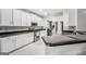Well-lit kitchen boasts white cabinets, stainless steel appliances, and elegant tile flooring at 242 Greenland Dr, Mcdonough, GA 30253