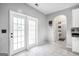 Bright mud room with white tile flooring, French doors, and adjacent laundry area at 242 Greenland Dr, Mcdonough, GA 30253