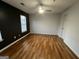 Bright bedroom with hardwood floors, ceiling fan, and a contemporary accent wall at 2353 Wellington Cir, Lithonia, GA 30058