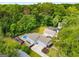 Aerial view of a home with mature tree cover, a pool and hot tub, and a long driveway at 1928 Main Nw St, Atlanta, GA 30318