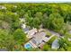 Aerial view of a home with mature tree cover, a pool and hot tub, and a long driveway in a neighborhood at 1928 Main Nw St, Atlanta, GA 30318