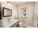 The bathroom features a single sink vanity with a light wood finish, a toilet, and a window at 1928 Main Nw St, Atlanta, GA 30318