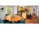 Dining area showcasing a wooden table, comfortable blue chairs, natural light, and a view into the kitchen at 1928 Main Nw St, Atlanta, GA 30318