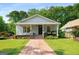Inviting single-story home with a cozy front porch, beautiful landscaping, and a brick walkway at 1928 Main Nw St, Atlanta, GA 30318