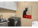 The laundry room features a stainless steel sink, a washer and dryer, and a novelty cat poster at 1928 Main Nw St, Atlanta, GA 30318