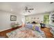 This main bedroom features a decorative rug, a chair, a ceiling fan, and several windows that allow natural light at 1928 Main Nw St, Atlanta, GA 30318