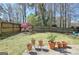 Well-maintained backyard offers a patio area and a beautiful backdrop with mature trees and flowering plants at 200 Doe Run, Peachtree City, GA 30269