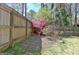 Serene backyard area featuring a birdbath, mature trees, and a wooden fence for added privacy at 200 Doe Run, Peachtree City, GA 30269
