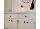 Bathroom vanity with white cabinets, dark hardware, and modern light fixture at 200 Doe Run, Peachtree City, GA 30269