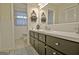 A bright bathroom with a wide mirror, white sink, and dark cabinets provides ample storage at 200 Doe Run, Peachtree City, GA 30269