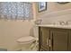 Charming half-bathroom featuring wainscoting, floral valance, and a modern dark vanity at 200 Doe Run, Peachtree City, GA 30269