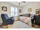 Bright bedroom featuring a daybed, plush chair, light hardwood floors, and natural light from the window at 200 Doe Run, Peachtree City, GA 30269