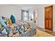 Bedroom with floral patterned bedspread, view of bathroom, and a wooden door at 200 Doe Run, Peachtree City, GA 30269